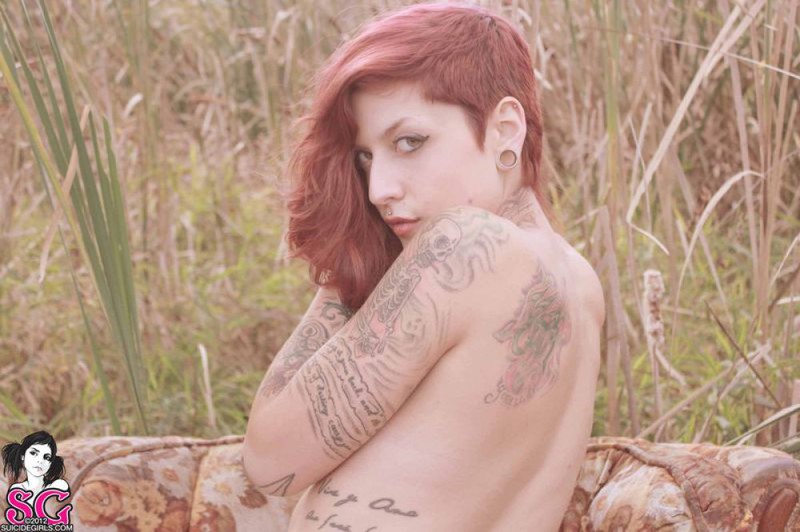 Татуированная бестия с рыжими волосами показала стриптиз посреди поля
